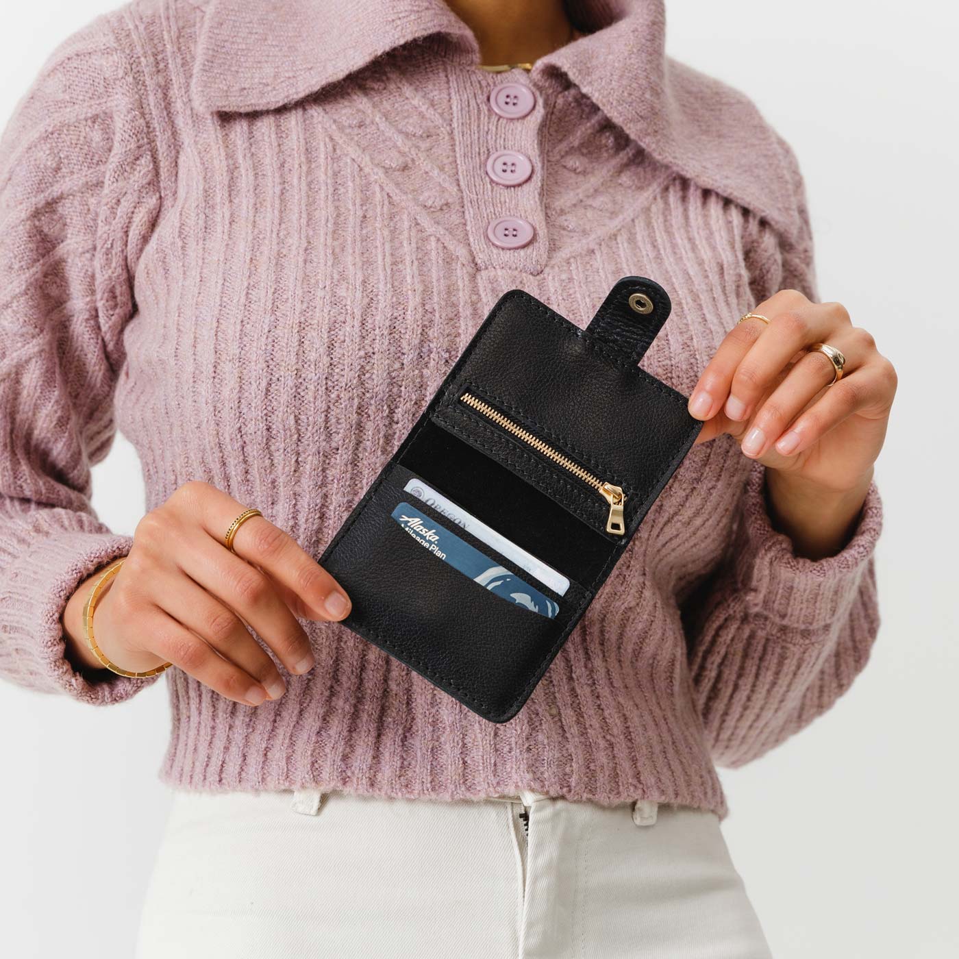 Pebbled--black | Model holding small leather bifold wallet with snap open