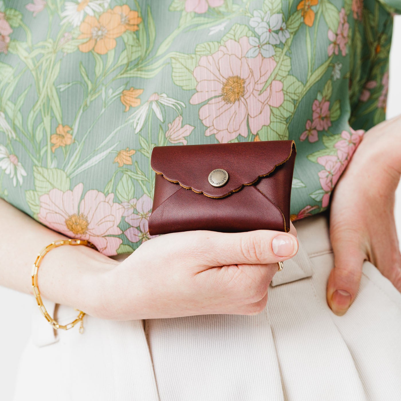 Cognac | Model holding small leather wallet with scalloped edge