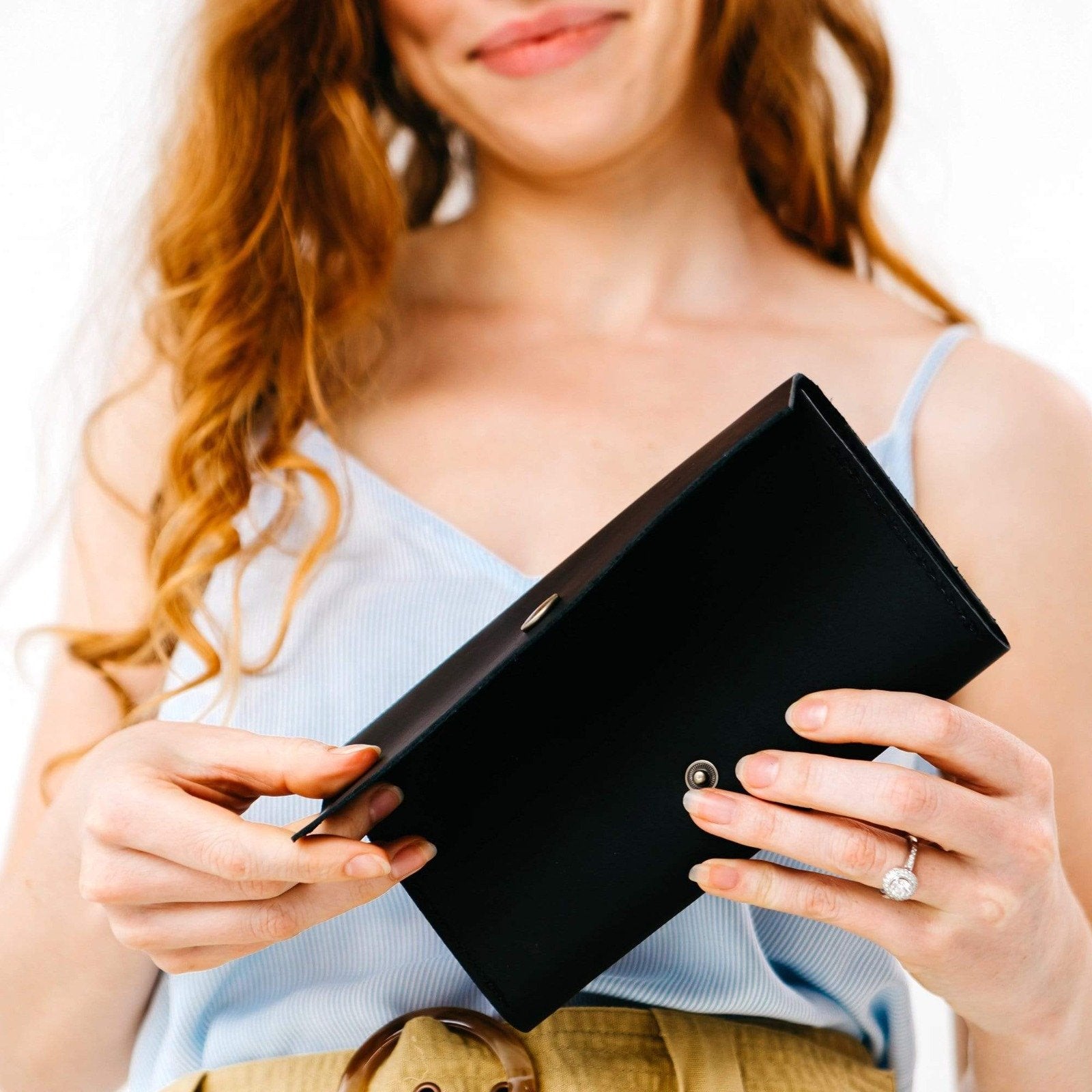 Black | Model holding leather wallet with snap closure open