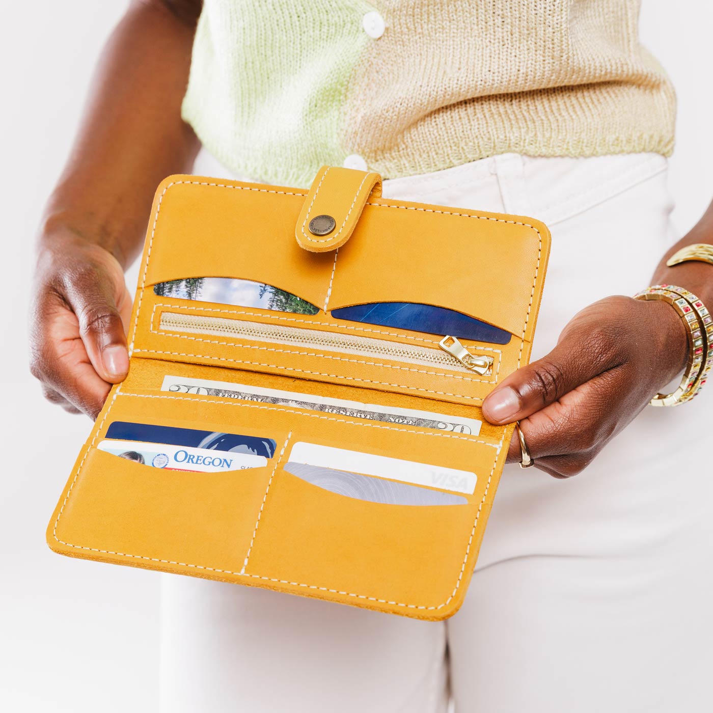 Sunflower | Model holding leather wallet with snap open