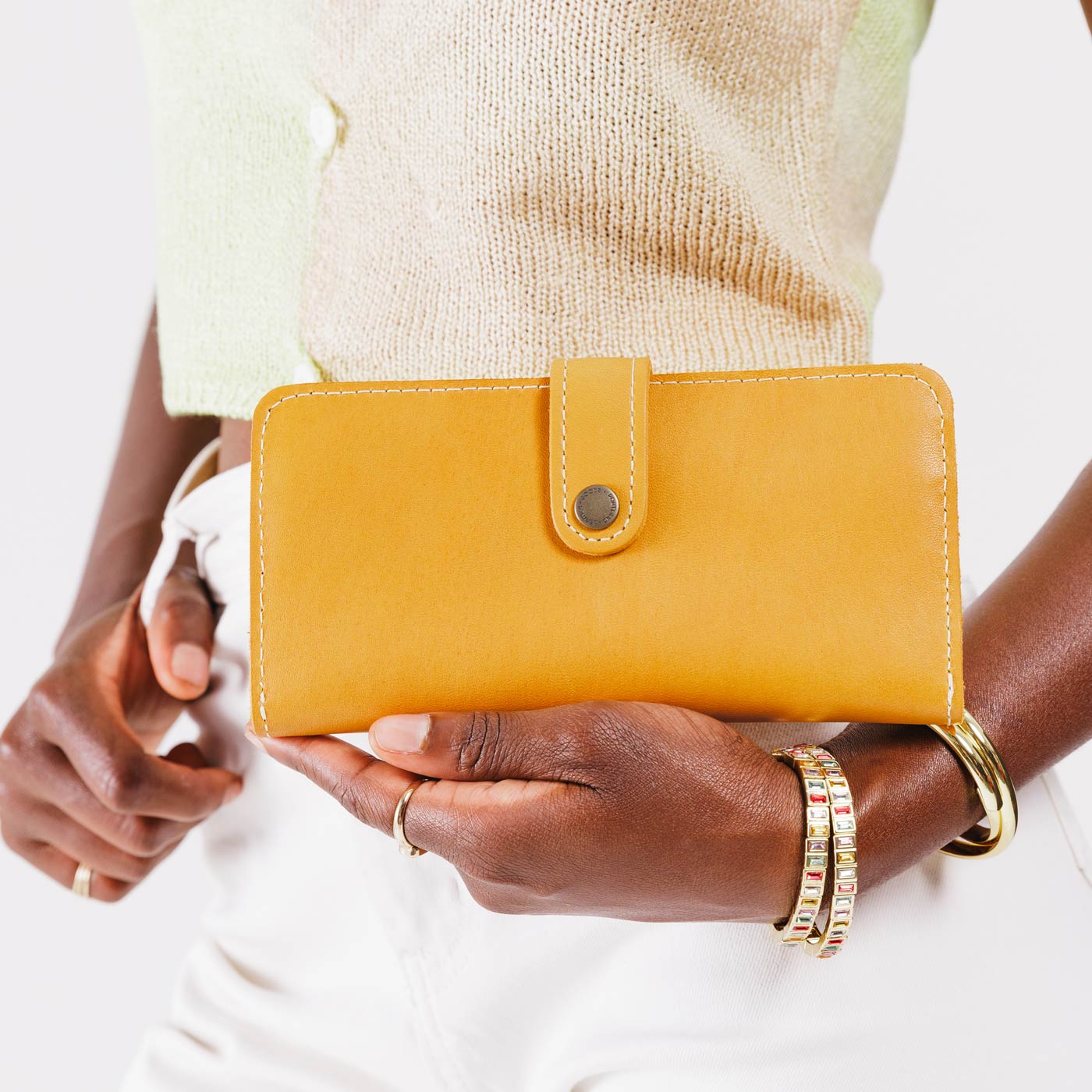 Sunflower | Model holding leather wallet with snap closed